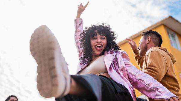
		Young woman dancing happily
	